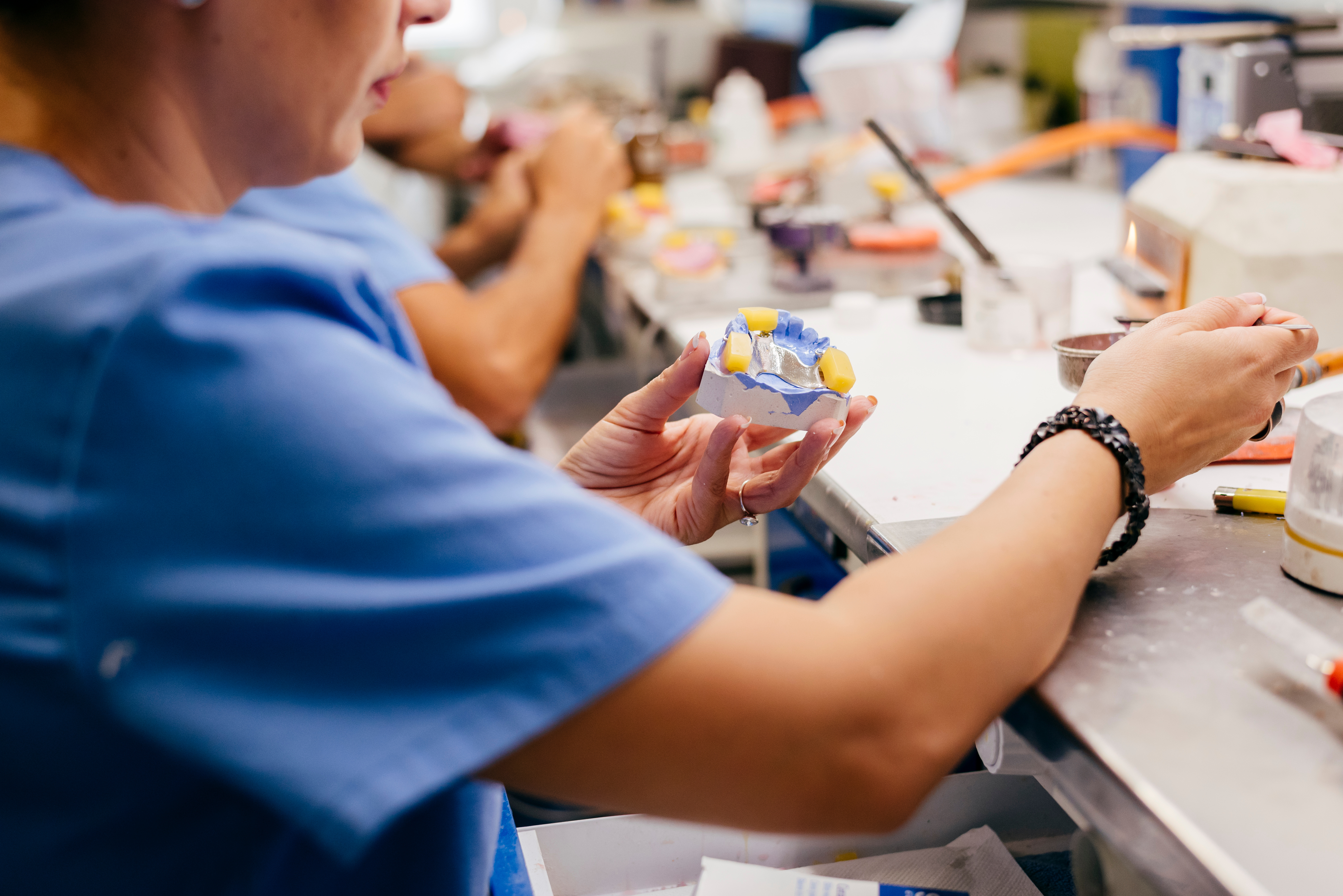 Caucasian woman working on a dental prosthesis in dental lab