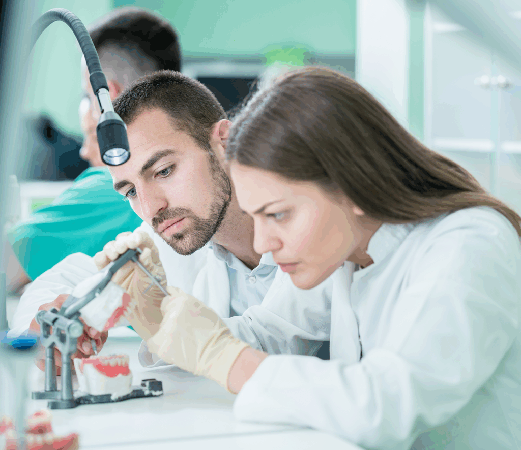 Male and female technicians working on dental products in a lab.