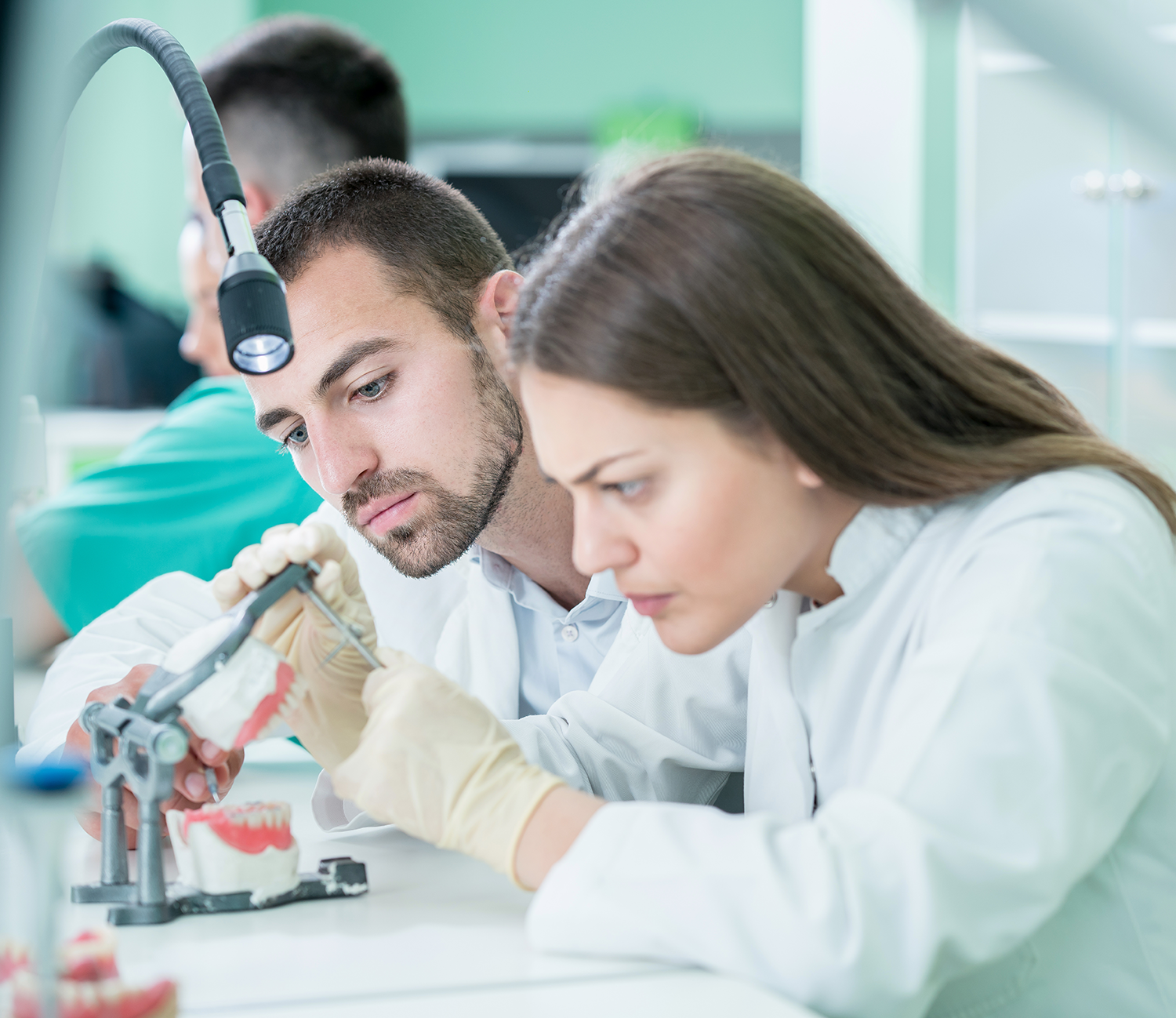 Male and female technicians working on dental products in a lab.
